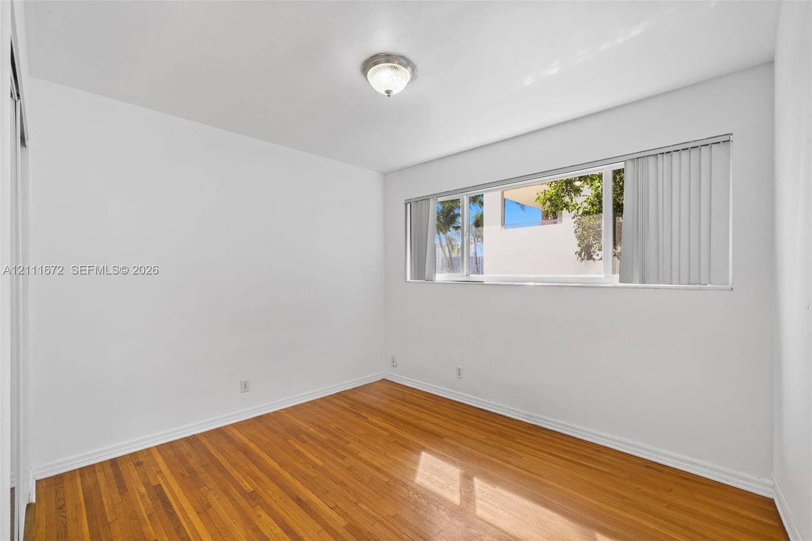Interior space featuring wood-finish flooring, a flush-mount ceiling light fixture, and horizontal sliding windows