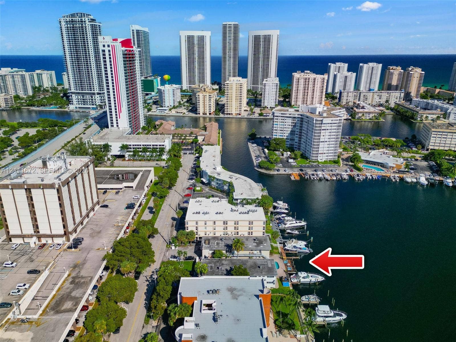 Aerial perspective of waterfront property featuring deep-water dockage, direct waterway access, and paved exterior grounds