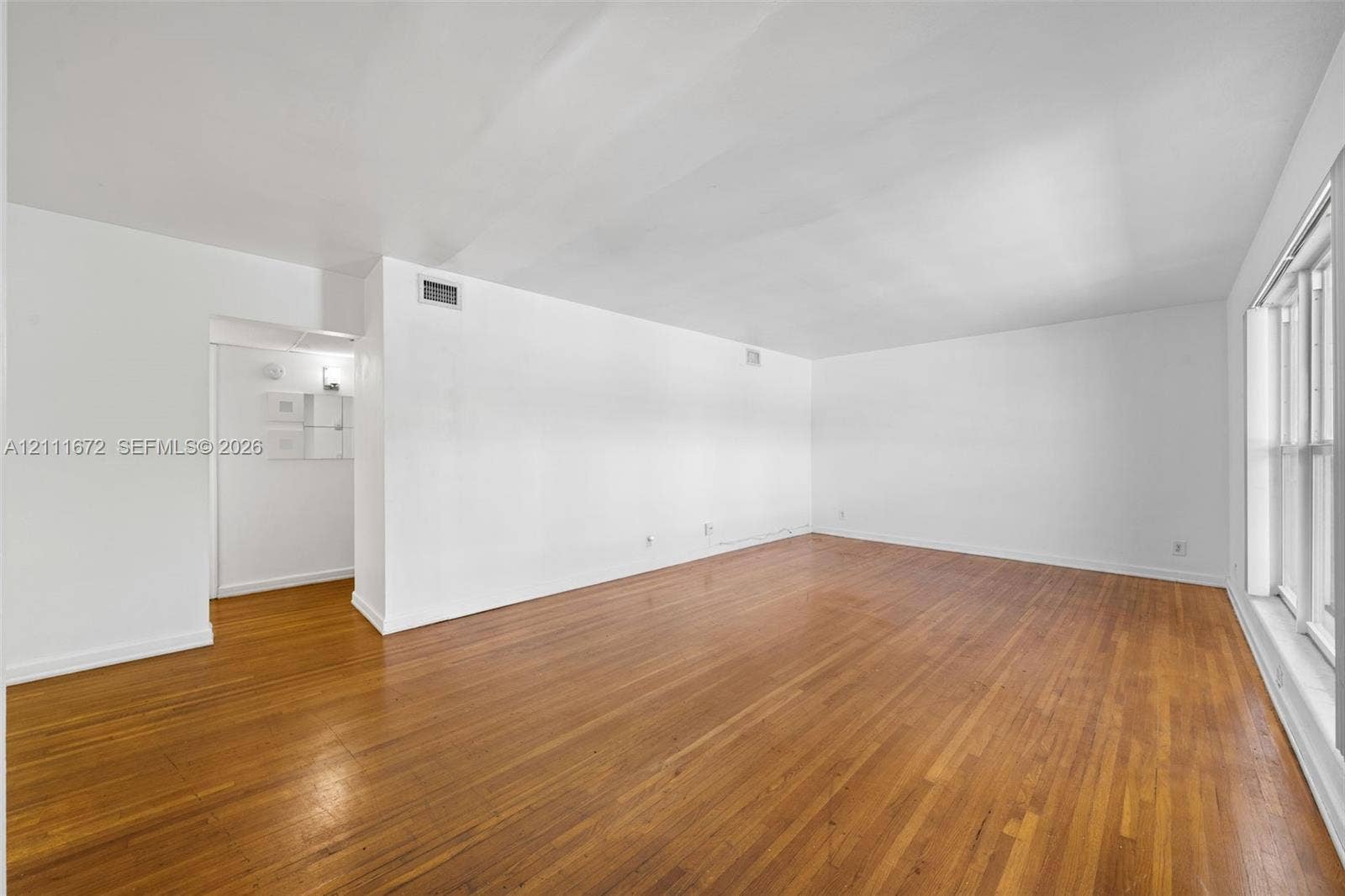 Open living space featuring wood-finish flooring and large windows