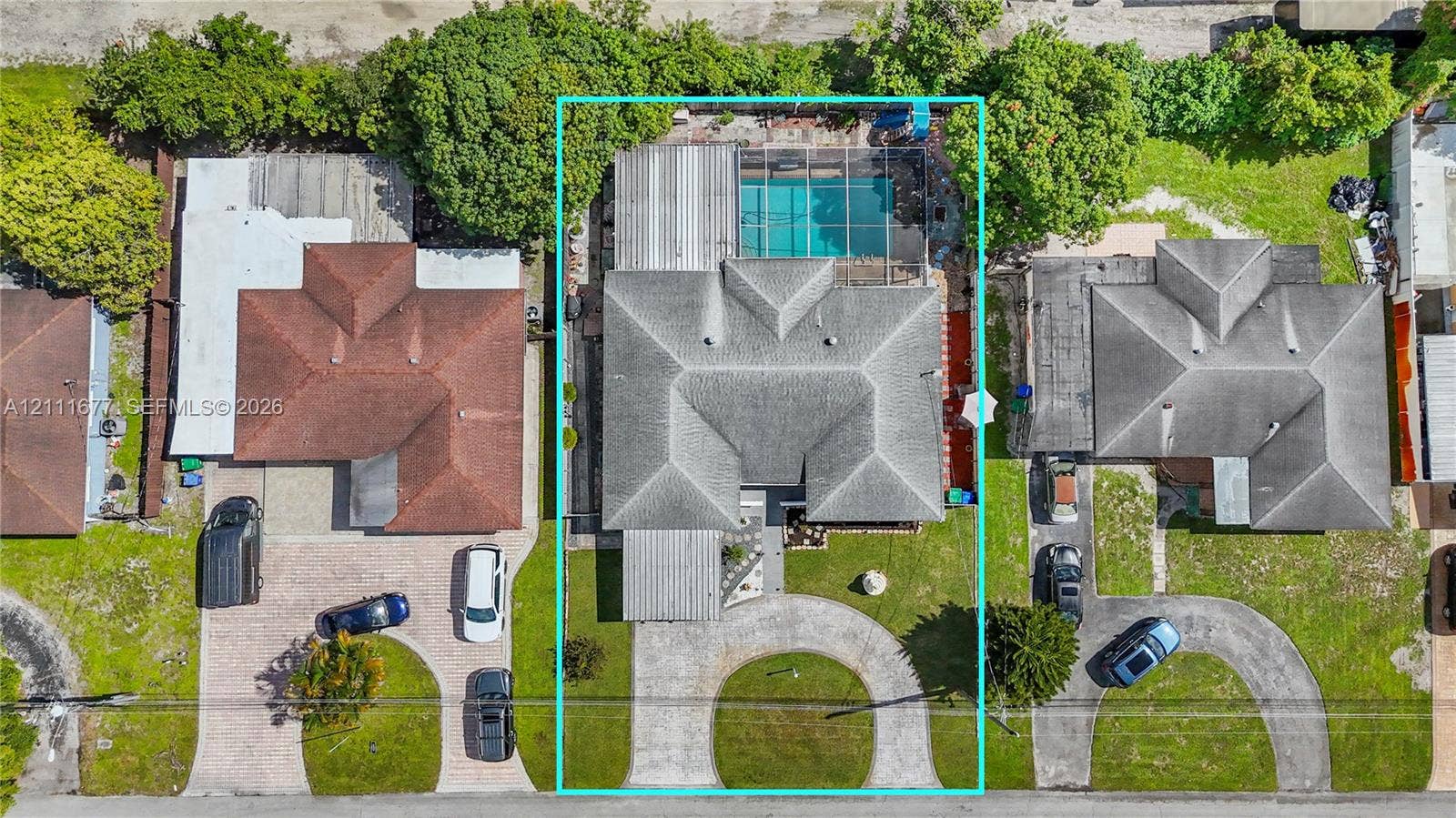 1921 Acapulco Drive, Miramar, FL 33023 Aerial view featuring a screened-in swimming pool, a multi-section roof, and a paved circular driveway