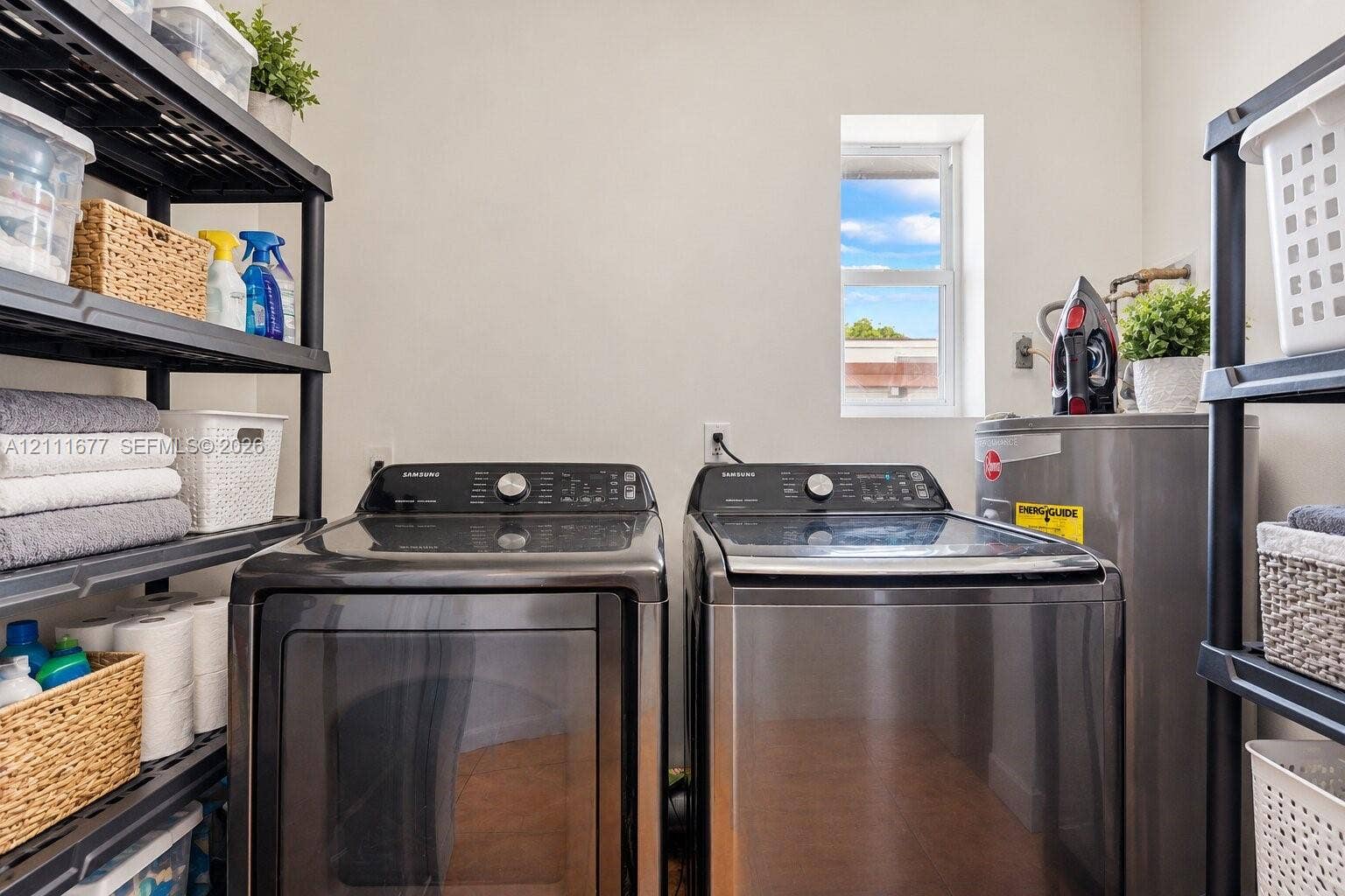 1921 Acapulco Drive, Miramar, FL 33023 Laundry area featuring stainless steel washer and dryer, tile flooring, and natural light from a vertical window