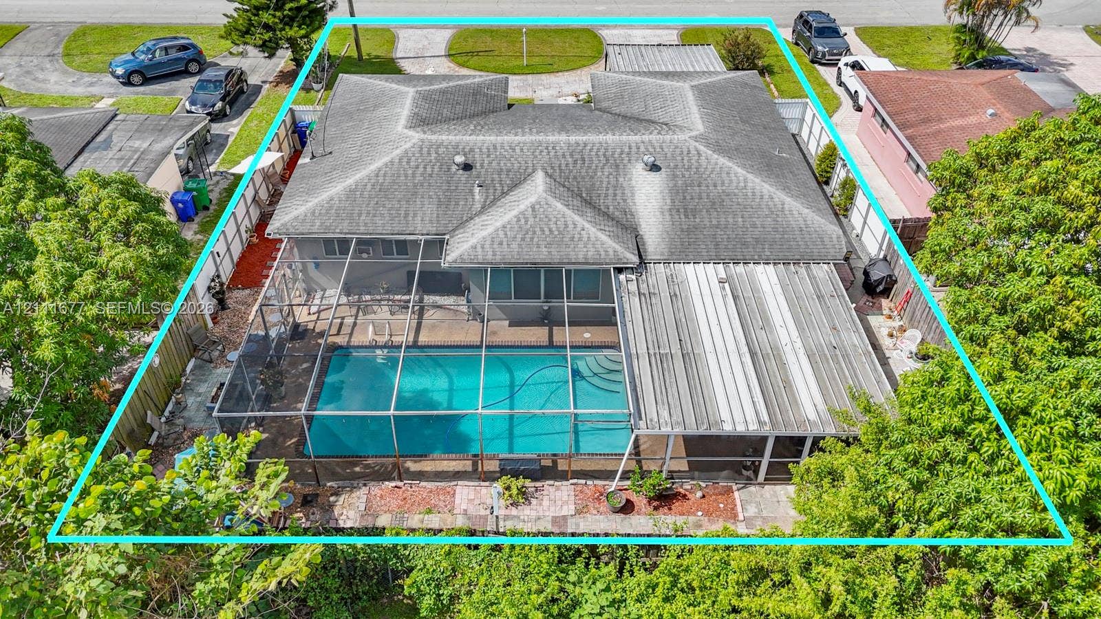 1921 Acapulco Drive, Miramar, FL 33023 Aerial view of property featuring a screened-in swimming pool, covered patio, fenced perimeter, and shingled roof