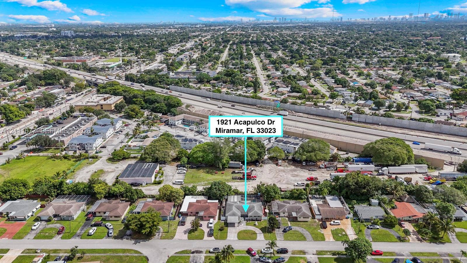 1921 Acapulco Drive, Miramar, FL 33023 Aerial perspective of a single-story residence featuring a concrete driveway, paved sidewalk, and mature landscaping