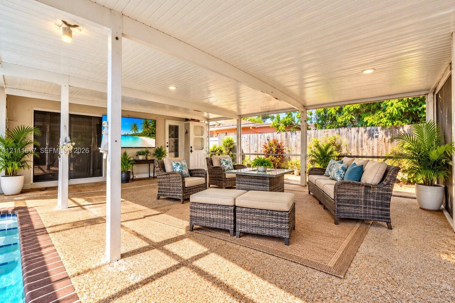 1921 Acapulco Drive, Miramar, FL 33023 Screened-in covered patio featuring a textured aggregate floor, recessed lighting, and sliding glass door access