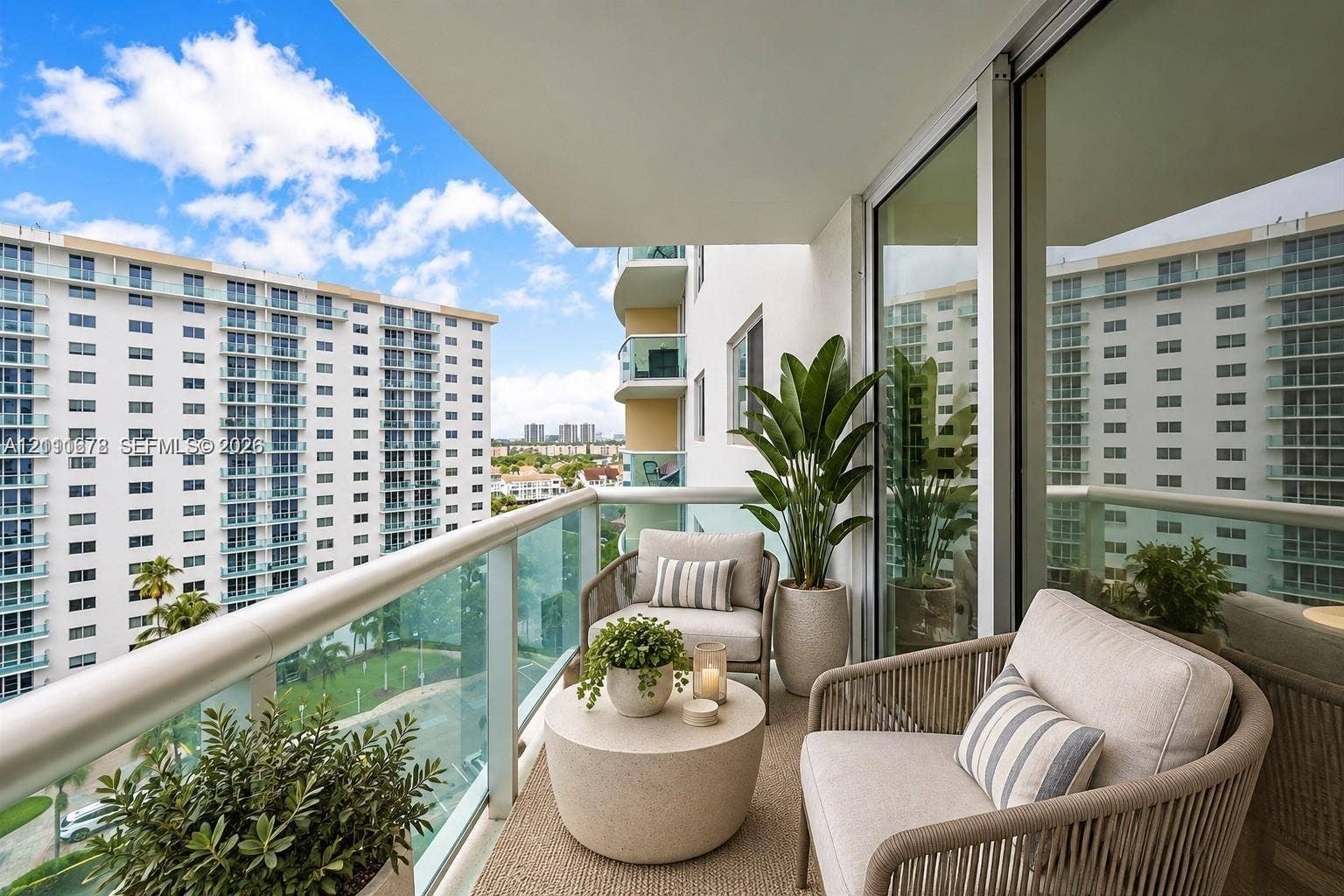 Covered balcony featuring a glass-panel railing, recessed lighting, and expansive sliding glass doors