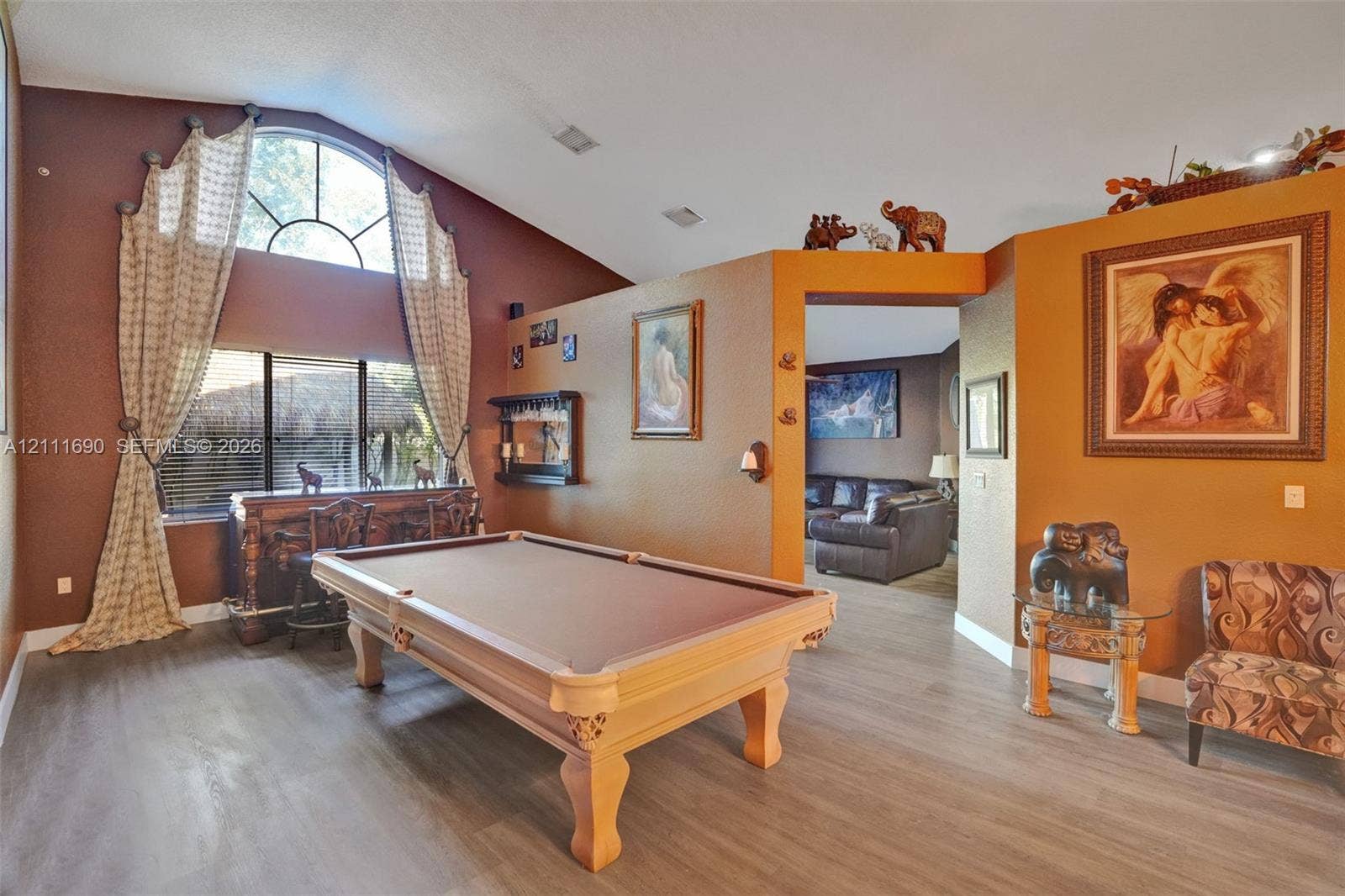 Vaulted ceilings, arched transom window, and wood-finish flooring