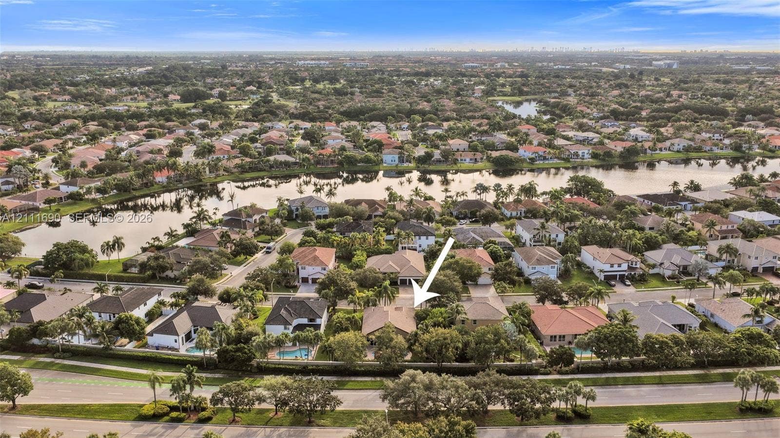 Aerial perspective showcasing a residential property with a tiled roof, mature landscaping, and an expansive backyard