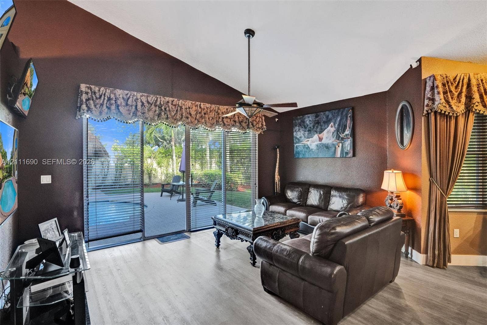 Vaulted ceilings, wood-finish flooring, and sliding glass doors providing outdoor access