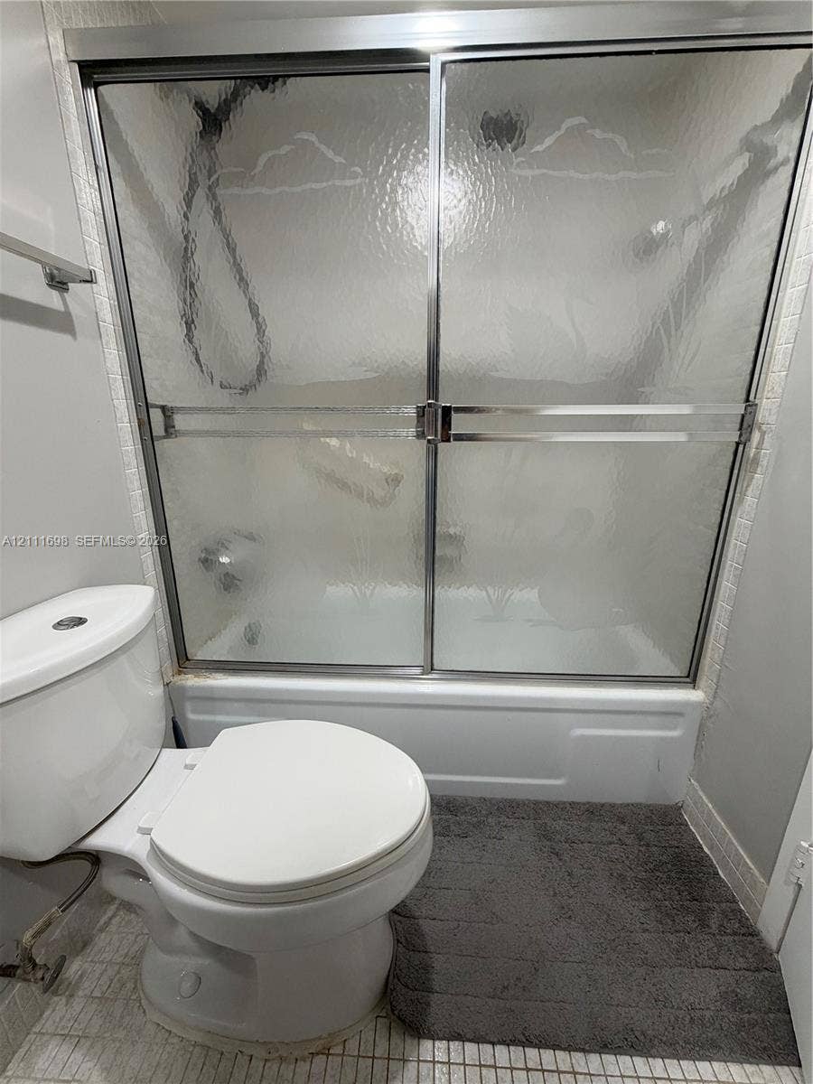 601 Three Islands Boulevard, #308, Hallandale Beach, Hallandale Beach, FL 33009 Bathtub and shower combination featuring a chrome-framed sliding glass enclosure, white porcelain-finish basin, and chrome hardware