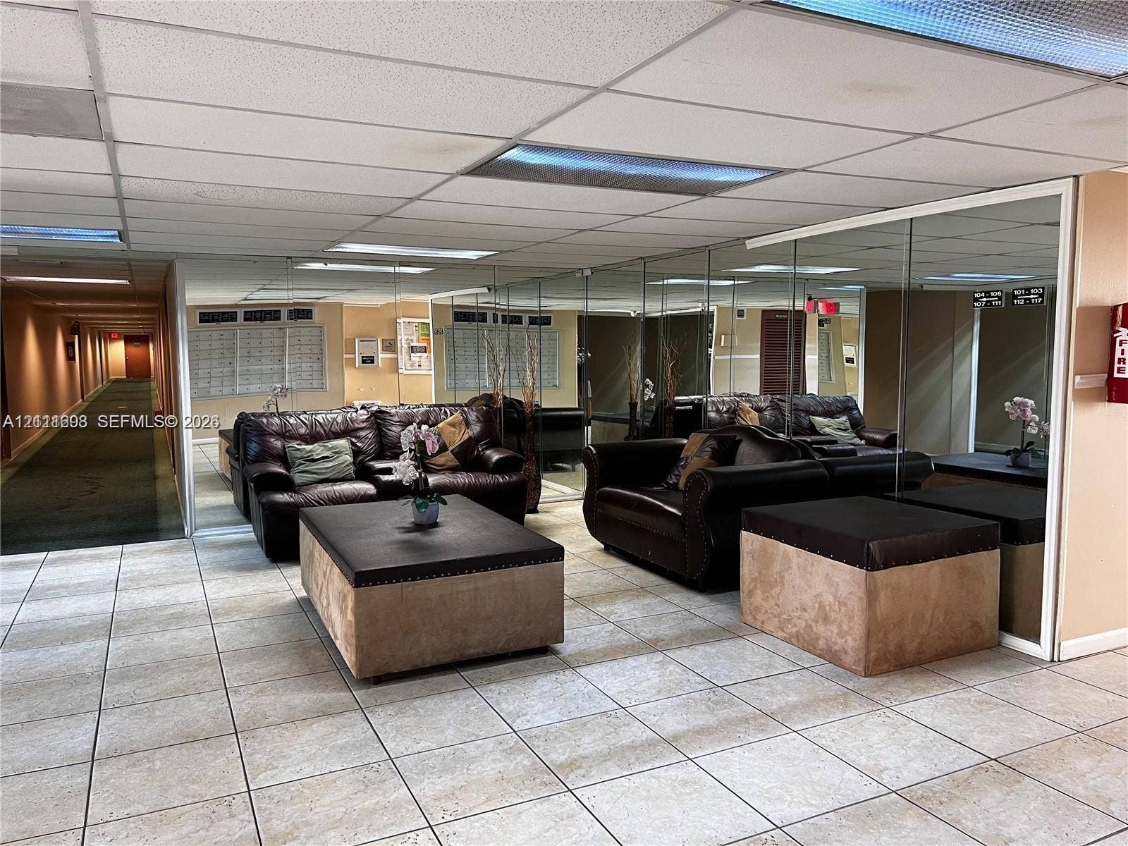 601 Three Islands Boulevard, #308, Hallandale Beach, Hallandale Beach, FL 33009 Common area featuring light-toned floor tiling, expansive floor-to-ceiling mirrored walls, and recessed grid ceiling lighting