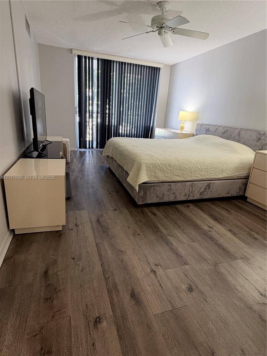 601 Three Islands Boulevard, #308, Hallandale Beach, Hallandale Beach, FL 33009 Wood-finish flooring, ceiling fan with integrated lighting, and full-length vertical window blinds