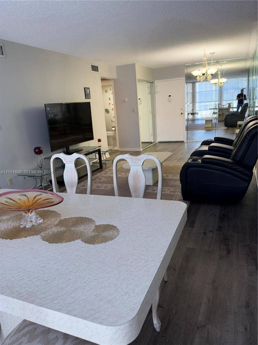 601 Three Islands Boulevard, #308, Hallandale Beach, Hallandale Beach, FL 33009 Wood-finish flooring, mirrored wall paneling, and multi-arm chandelier lighting