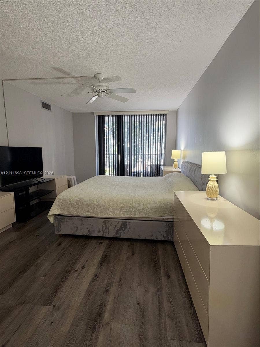 601 Three Islands Boulevard, #308, Hallandale Beach, Hallandale Beach, FL 33009 Wood-finish flooring, neutral wall tones, ceiling fan, and vertical blinds
