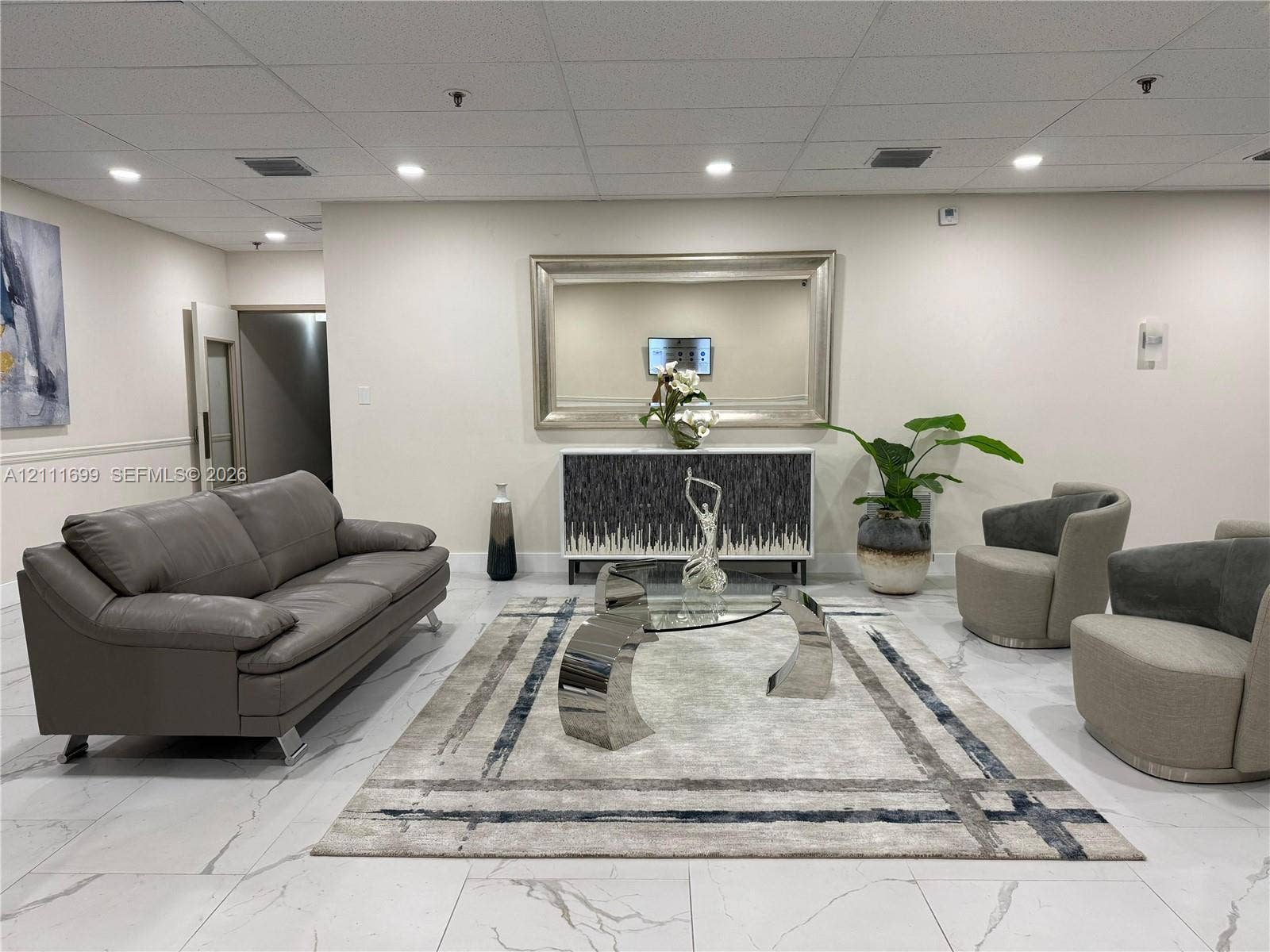 Large-format tile flooring with marble-style veining, recessed ceiling lighting, and a neutral wall finish