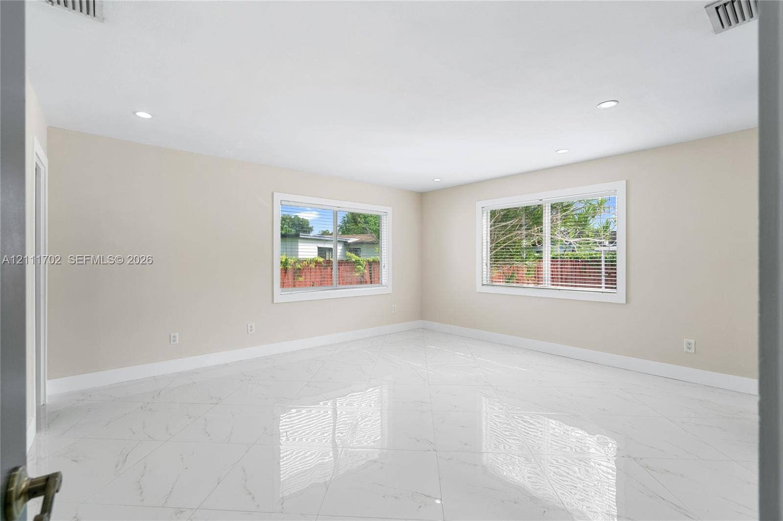 Spacious interior featuring large-format tile flooring, recessed lighting, and expansive windows
