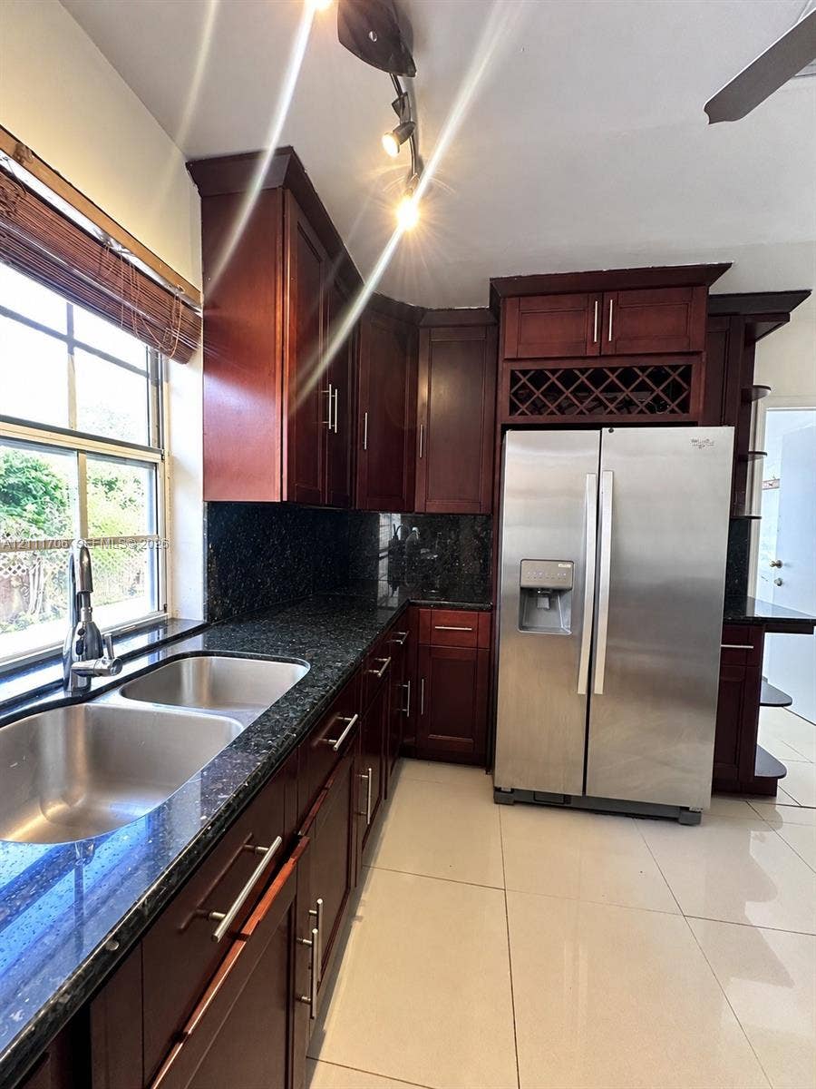 2222 SW 19th Avenue, Miami, Miami, FL 33145 Kitchen featuring dark wood-finish cabinetry, stone countertops, integrated wine rack, stainless steel double-basin sink, and ceramic tile flooring