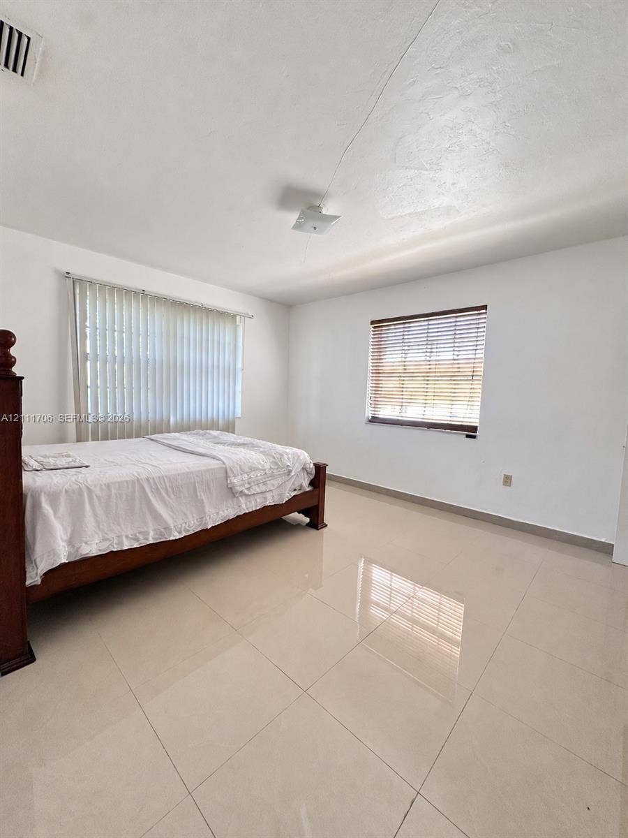 2222 SW 19th Avenue, Miami, Miami, FL 33145 Spacious room with polished tile flooring, neutral wall finishes, vertical blinds, and horizontal slatted window treatments
