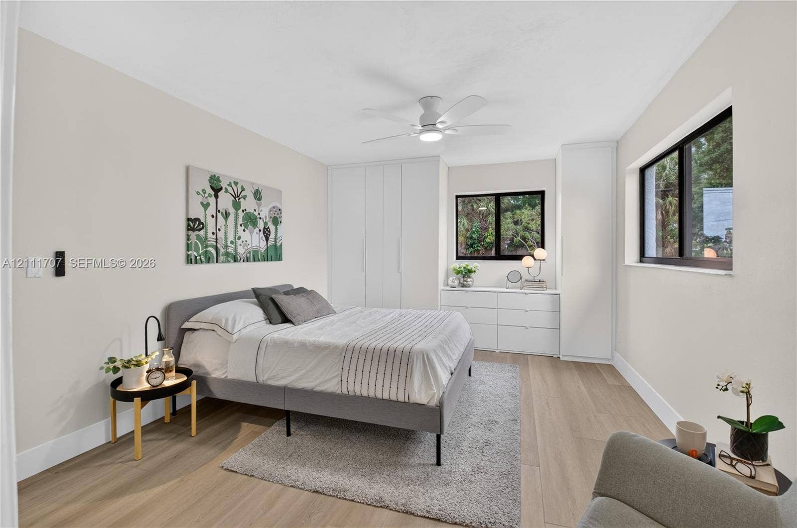 301 SW 12th Avenue, Delray Beach, FL 33444 Room featuring wood-finish flooring, built-in floor-to-ceiling cabinetry, dual windows with black frames, and a ceiling-mounted light fixture
