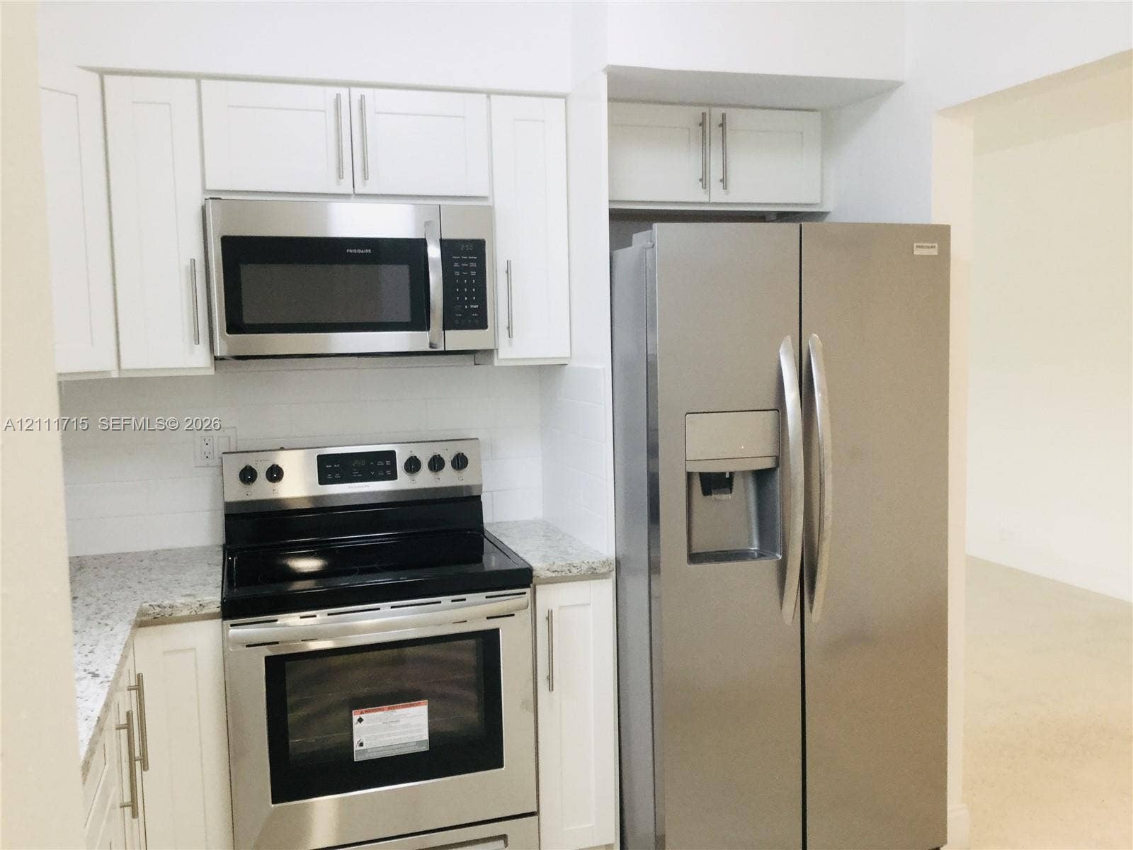 18280 NE Glades Drive, North Miami Beach, North Miami Beach, FL 33162 Kitchen featuring white shaker-style cabinetry, stone-finish countertops, stainless steel appliances, and an over-the-range microwave