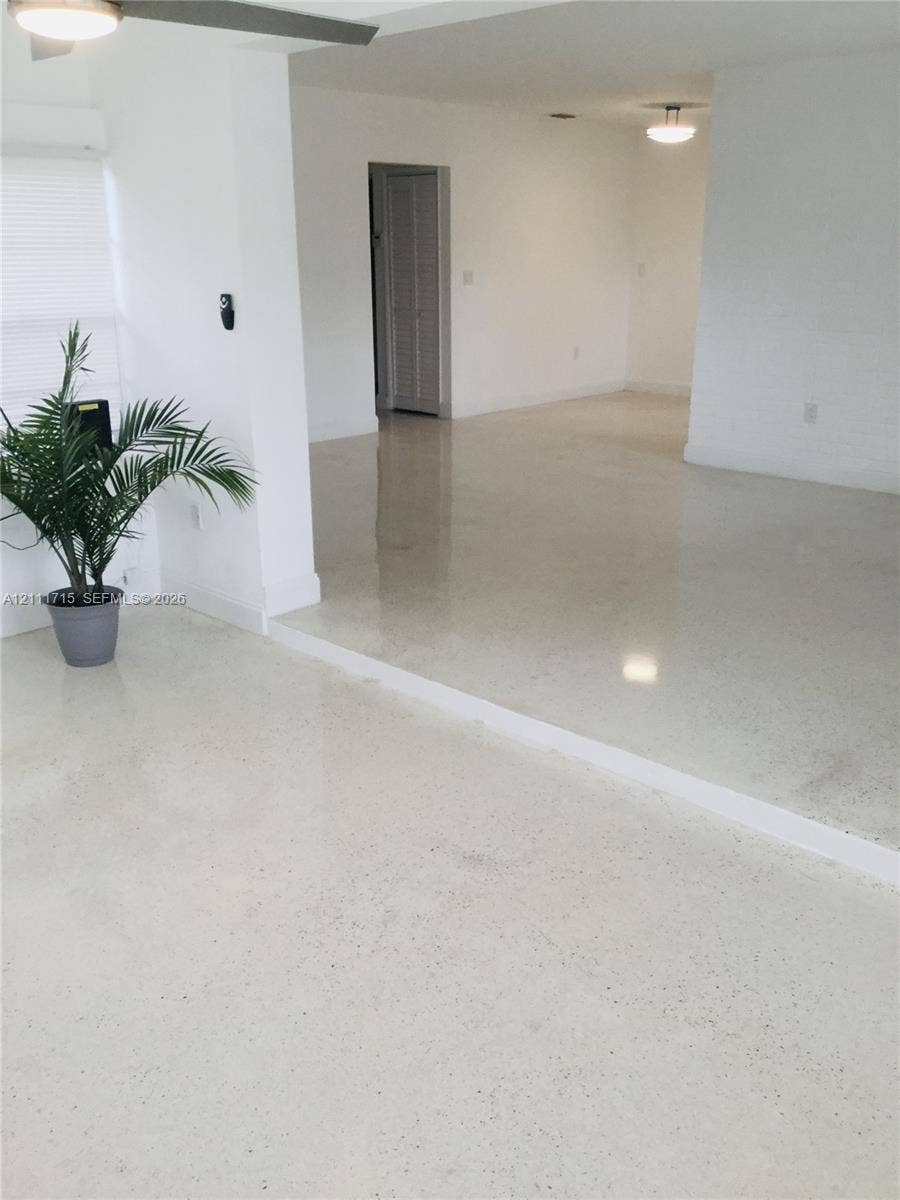 18280 NE Glades Drive, North Miami Beach, North Miami Beach, FL 33162 Polished concrete flooring, split-level floor plan, flush-mount ceiling lighting, and louvered bifold closet doors