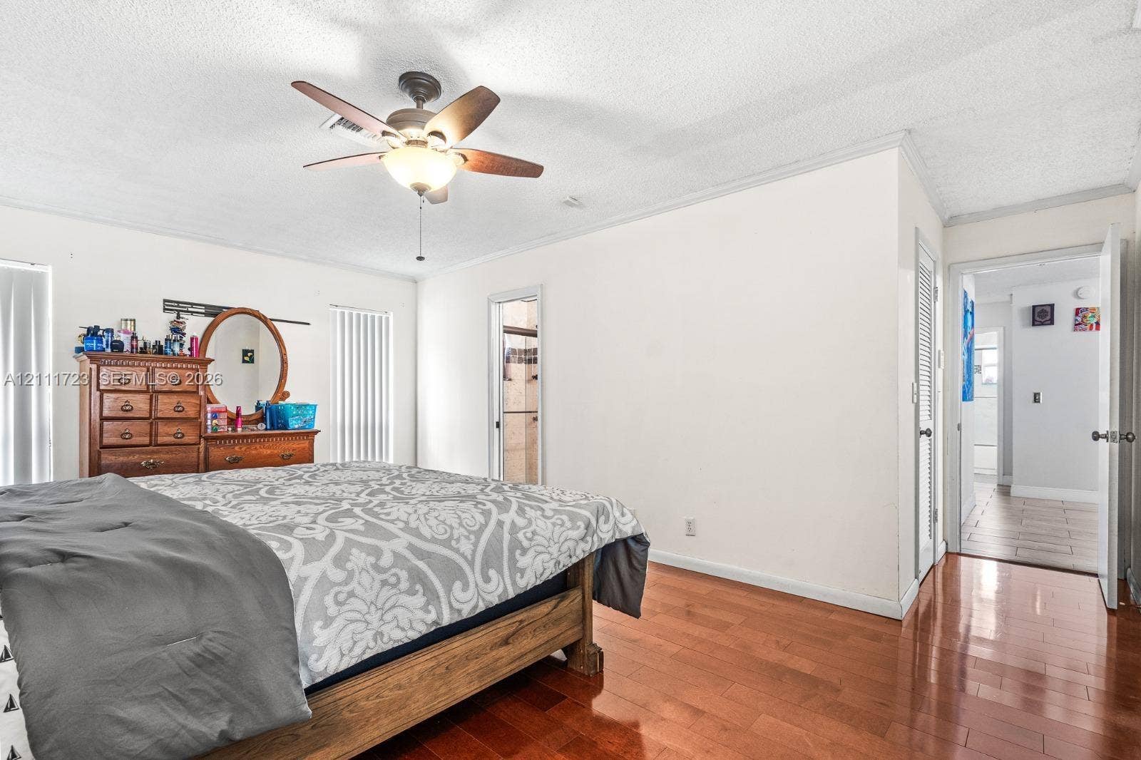 8541 NW 51st Court, Lauderhill, FL 33351 Room featuring wood-finish flooring, ceiling fan with integrated light fixture, crown molding, and vertical blinds