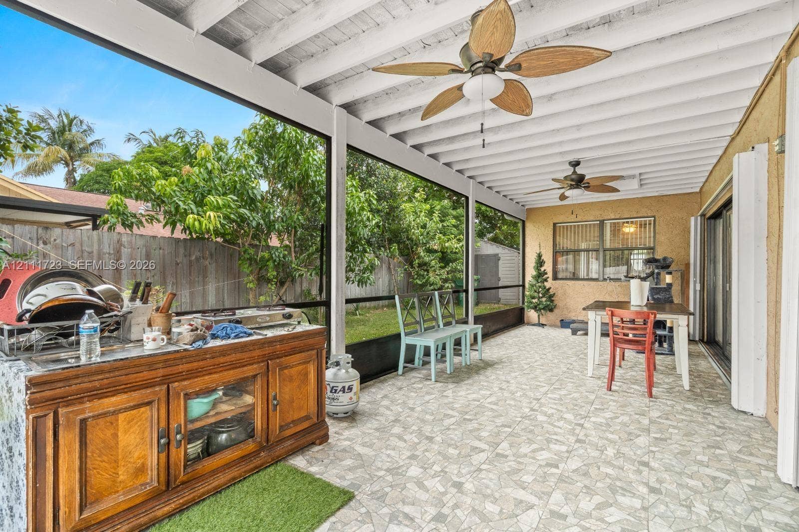 8541 NW 51st Court, Lauderhill, FL 33351 Screened-in patio featuring tiled flooring, dual ceiling fans, and an exterior wall finish