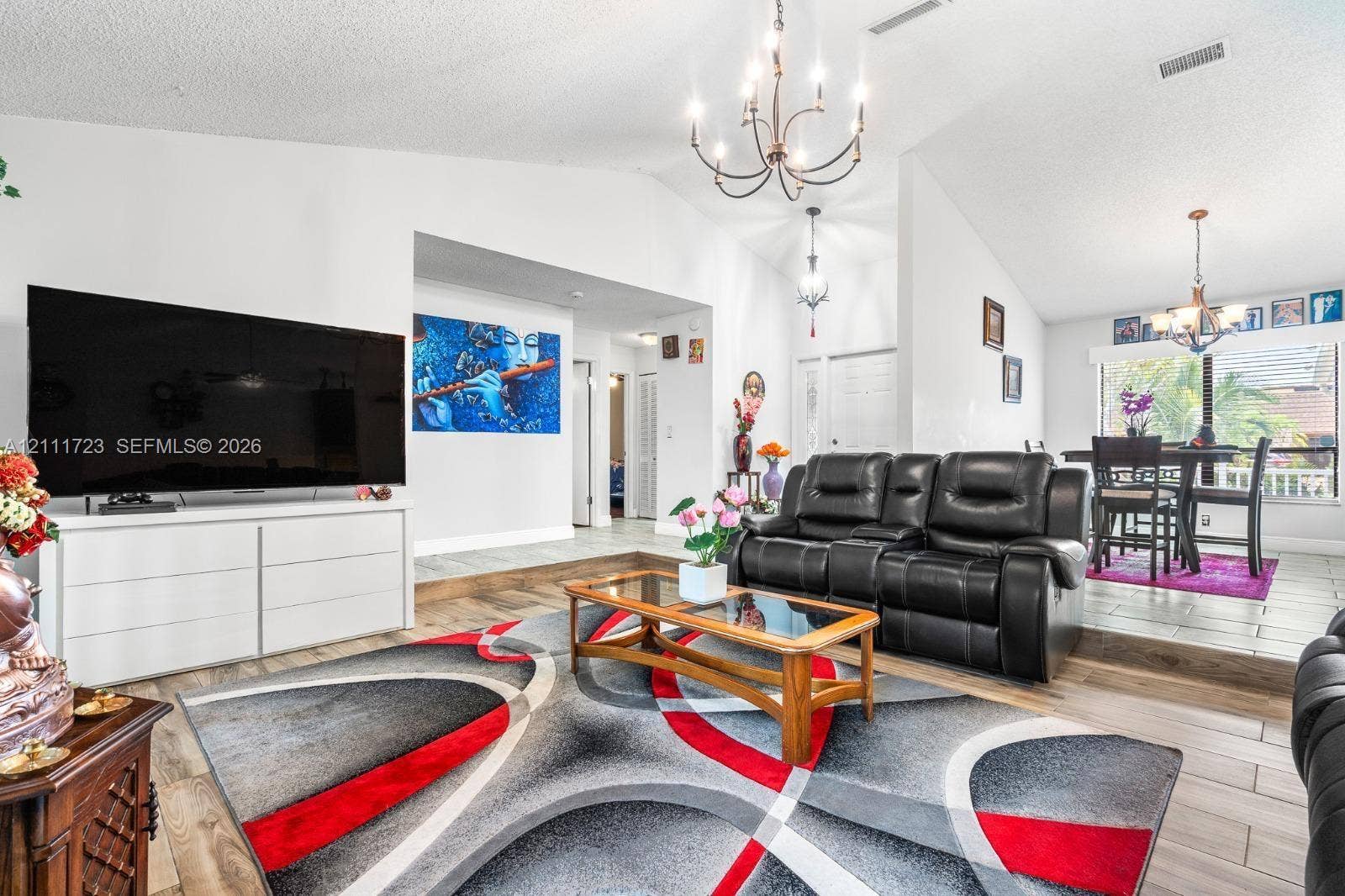 8541 NW 51st Court, Lauderhill, FL 33351 Vaulted ceilings with exposed traditional chandeliers, wood-finish flooring, and a multi-level floor plan