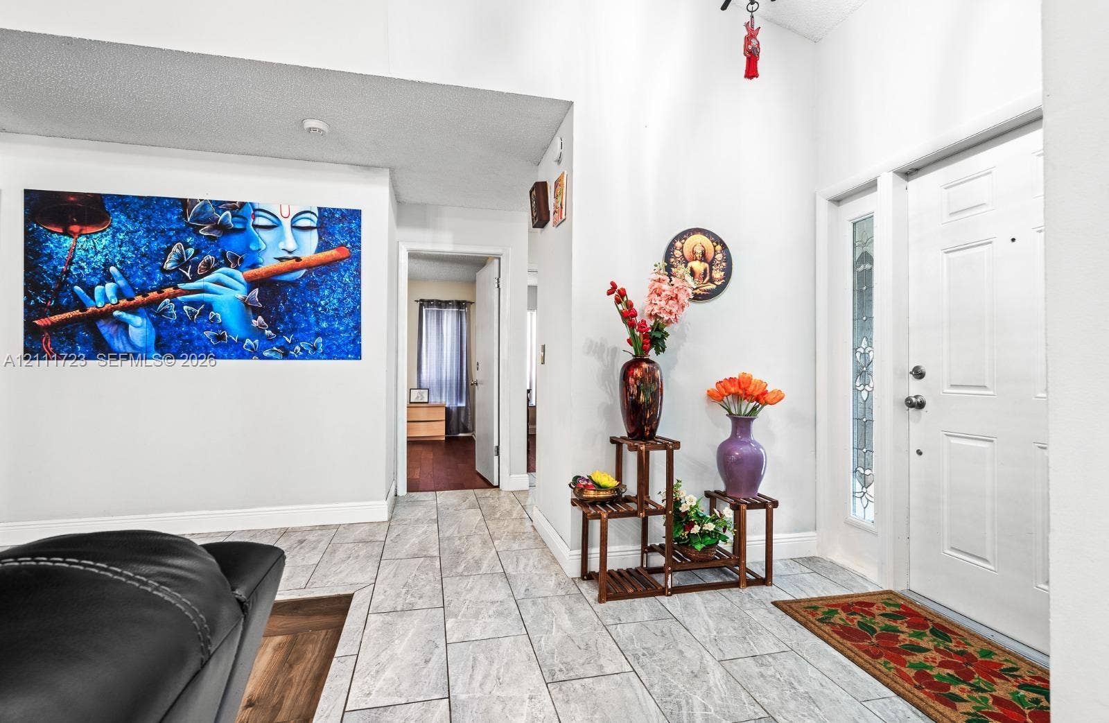 8541 NW 51st Court, Lauderhill, FL 33351 Foyer featuring light-toned stone-finish tile flooring and an entry door with decorative glass side-lite