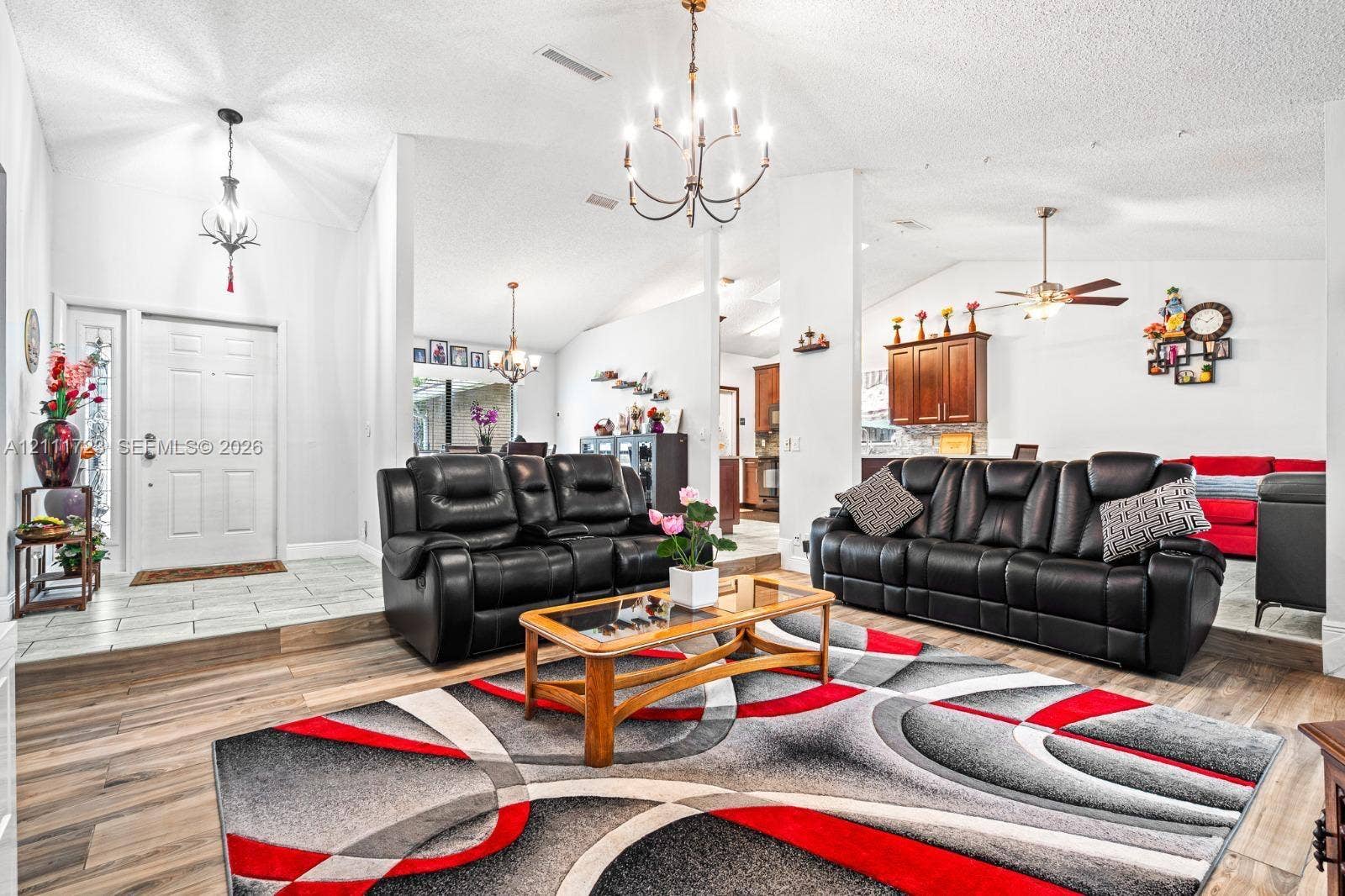 8541 NW 51st Court, Lauderhill, FL 33351 Vaulted ceilings with exposed metal chandeliers, wood-finish flooring, and a multi-level floor plan featuring decorative tile accents