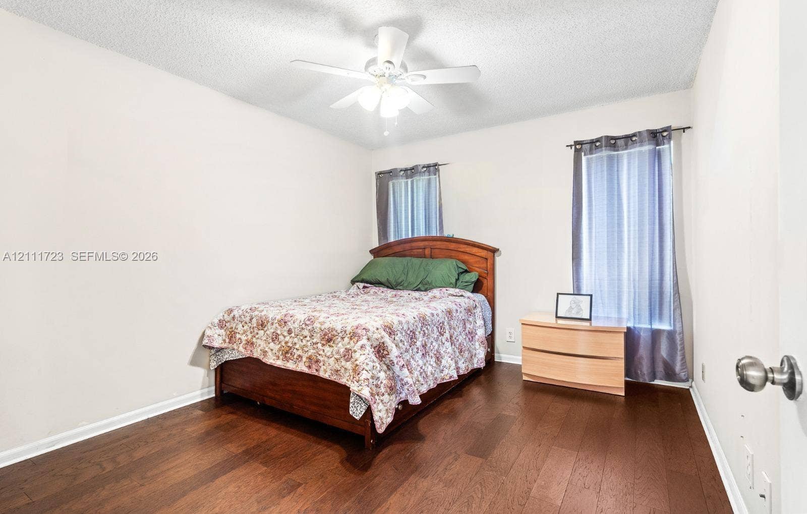 8541 NW 51st Court, Lauderhill, FL 33351 Room featuring wood-finish flooring, dual windows, and an overhead ceiling fan with integrated light fixture