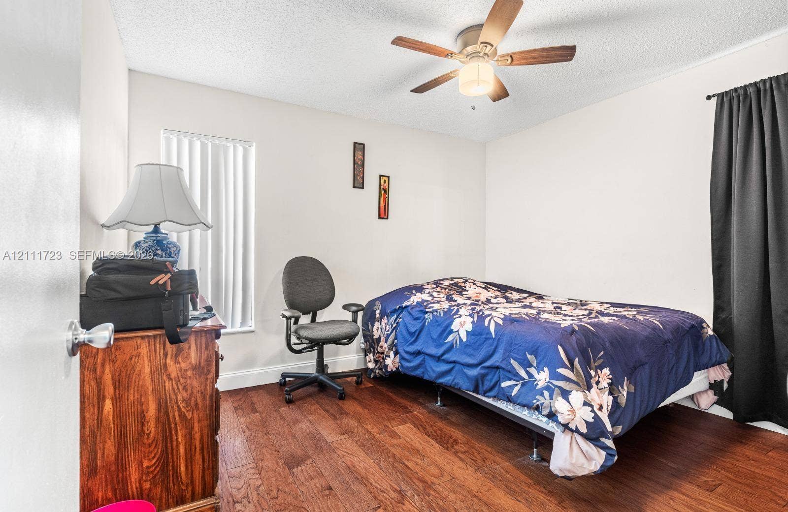 8541 NW 51st Court, Lauderhill, FL 33351 Interior room featuring wood-finish flooring, a ceiling fan with integrated lighting, and vertical window blinds