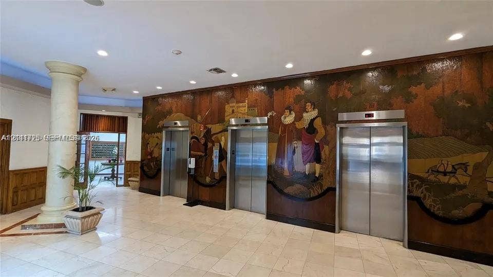 3725 S Ocean Drive, #508, Hollywood, Hollywood, FL 33019 Lobby featuring a large-scale decorative mural, three stainless steel elevator doors, polished stone flooring, and a structural column