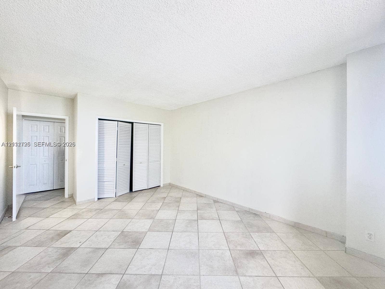 3725 S Ocean Drive, #508, Hollywood, Hollywood, FL 33019 Neutral-toned tile flooring, white walls, and multiple sets of white louvered-door closets