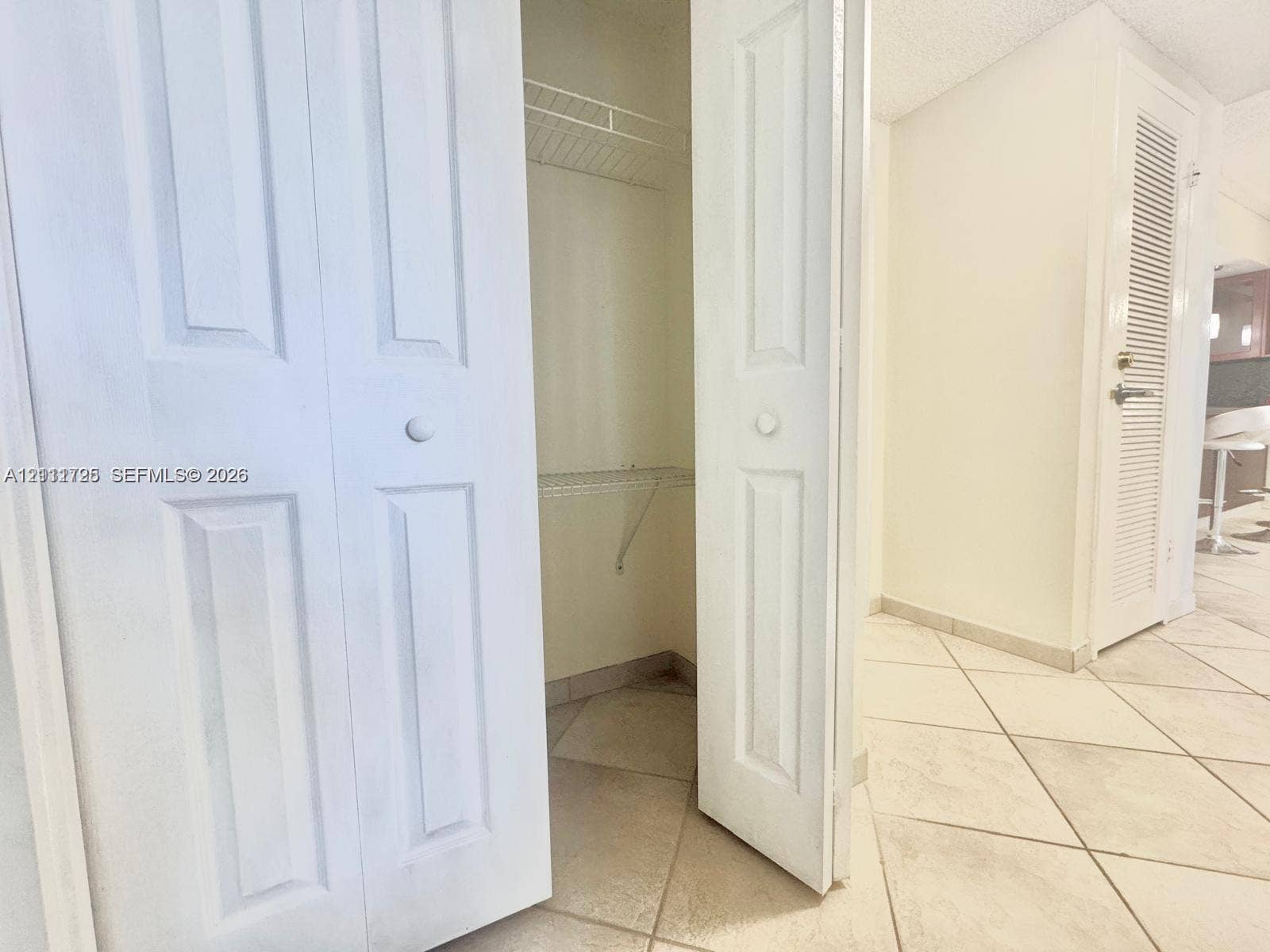 3725 S Ocean Drive, #508, Hollywood, Hollywood, FL 33019 White bi-fold closet doors featuring panel detailing, integrated wire shelving, and neutral ceramic tile flooring