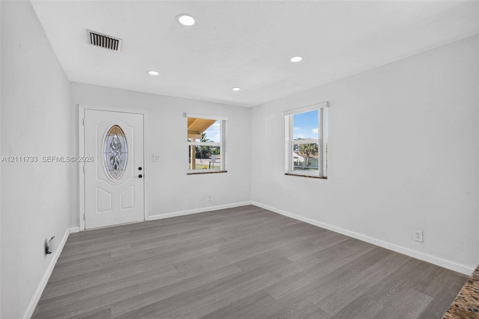 Interior space featuring wood-finish flooring, recessed lighting, and an exterior door with an oval decorative glass insert