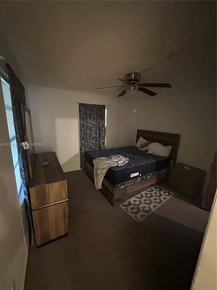 Carpeted flooring, multi-pane windows, and a ceiling fan with integrated lighting