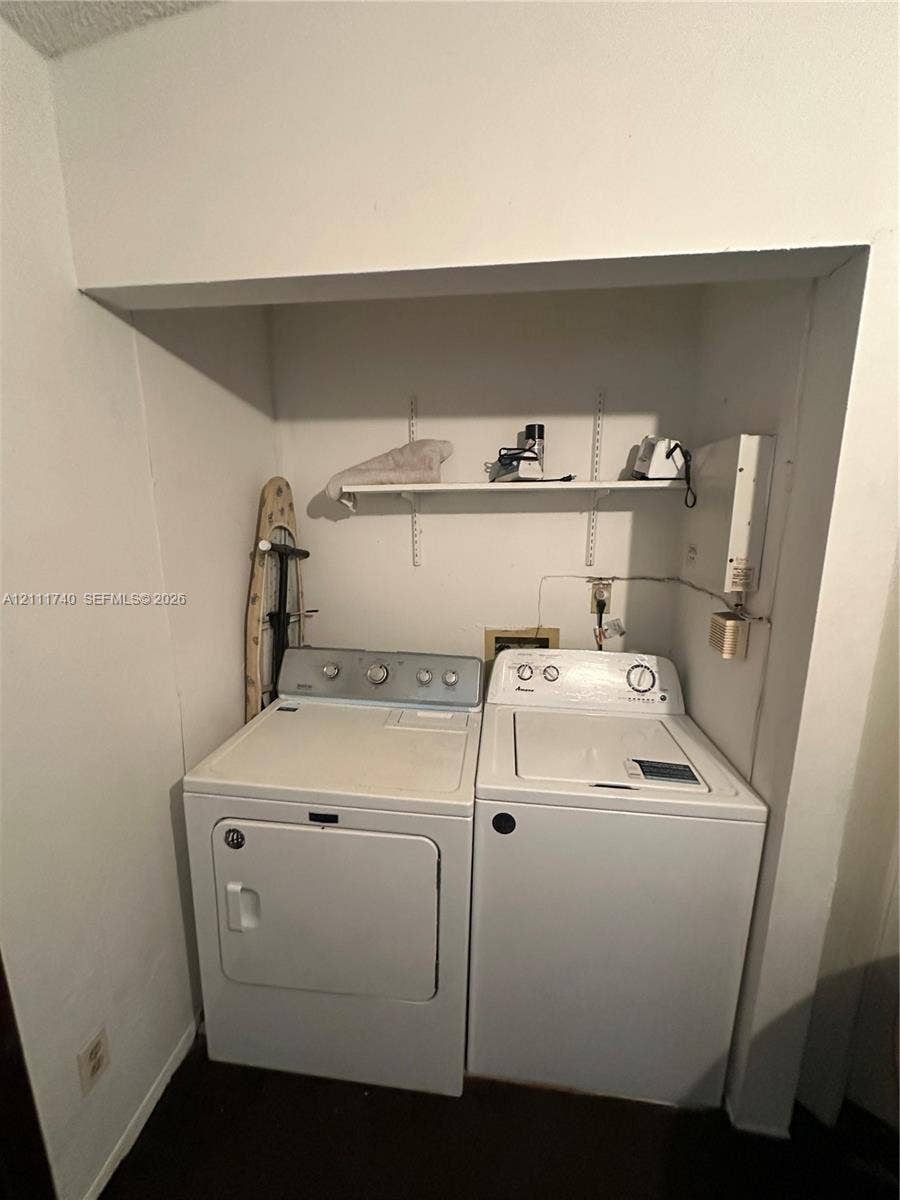 Laundry alcove featuring built-in shelving with adjustable wall-mounted tracks