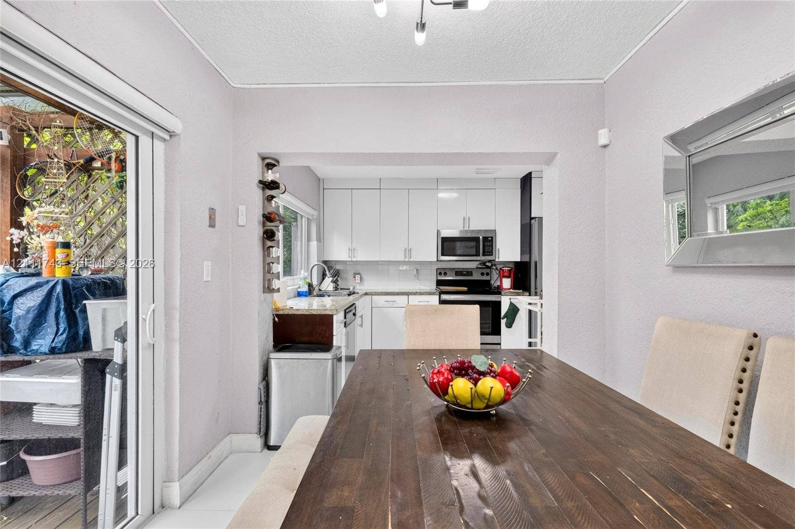5524 N Andrews Avenue, Oakland Park, FL 33309 Kitchen featuring white shaker-style cabinetry, stone countertops, and built-in stainless steel appliances, including a microwave and range