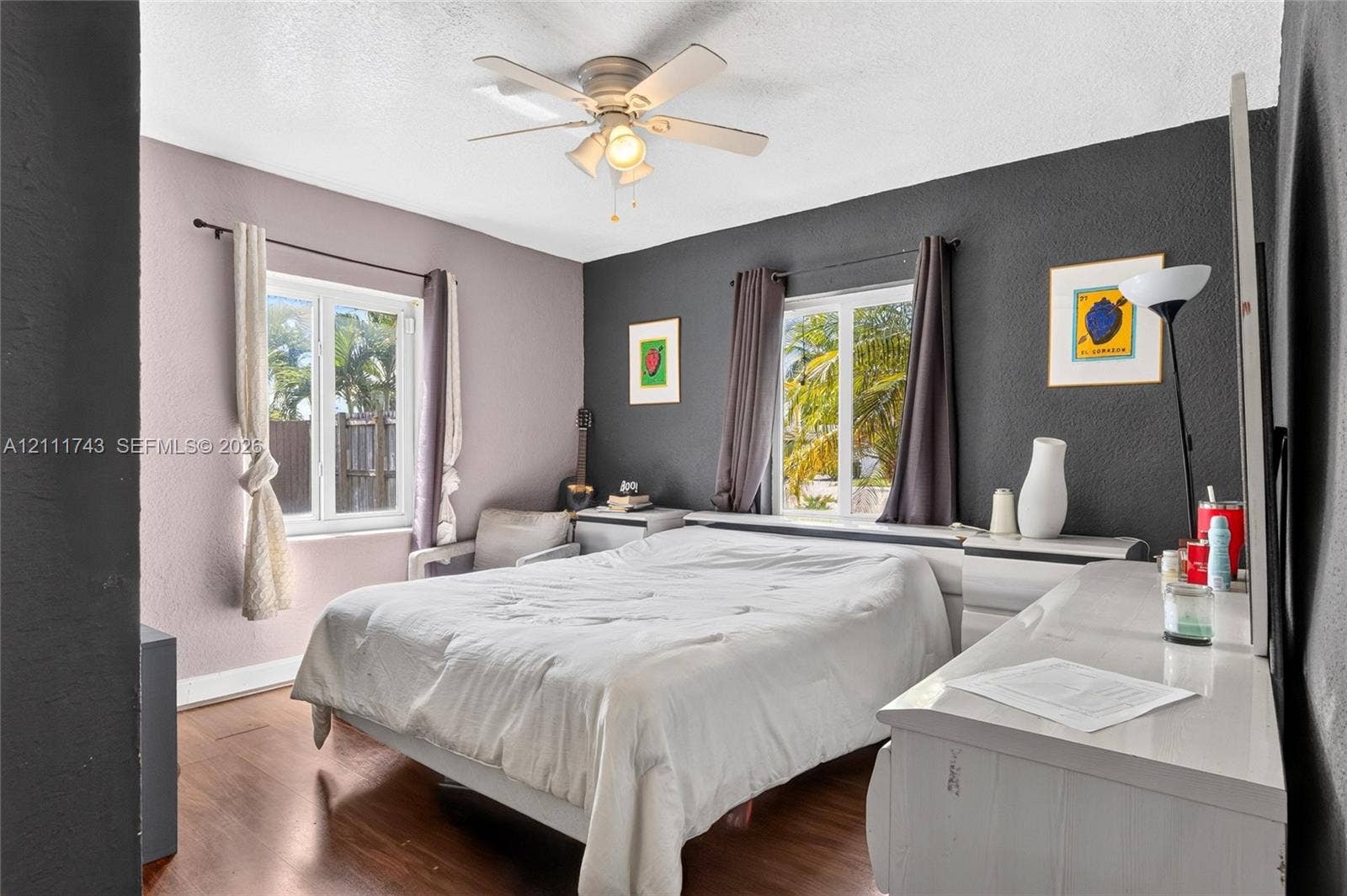 5524 N Andrews Avenue, Oakland Park, FL 33309 Wood-finish flooring, dual windows with deep-set frames, and a ceiling-mounted light fixture with a multi-blade fan