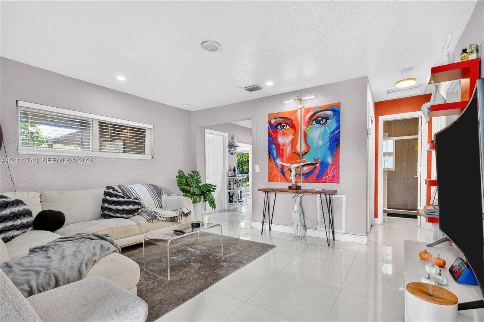 5524 N Andrews Avenue, Oakland Park, FL 33309 Living area featuring high-gloss tile flooring, recessed lighting, and a horizontal window with blinds