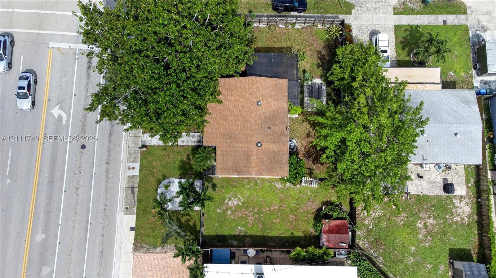 5524 N Andrews Avenue, Oakland Park, FL 33309 Aerial perspective featuring a residential lot with mature trees, a shingle-style roof, and a fenced backyard