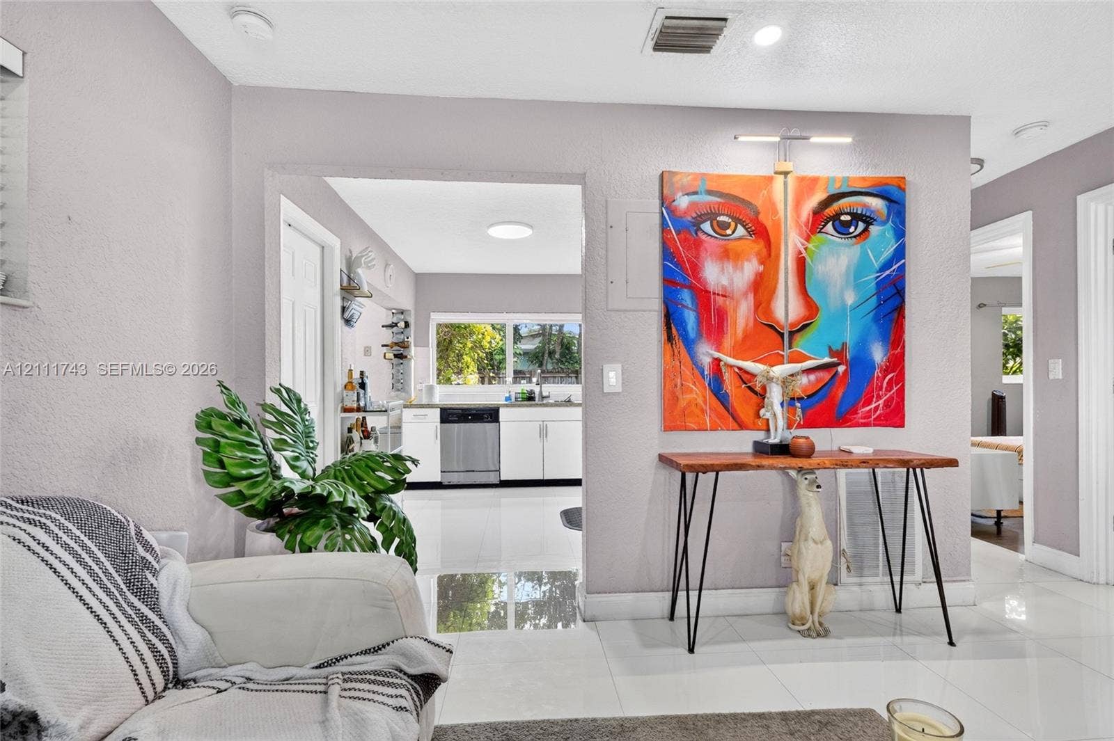 5524 N Andrews Avenue, Oakland Park, FL 33309 Polished tile flooring, recessed ceiling lighting, and white cabinetry featuring a stainless steel dishwasher
