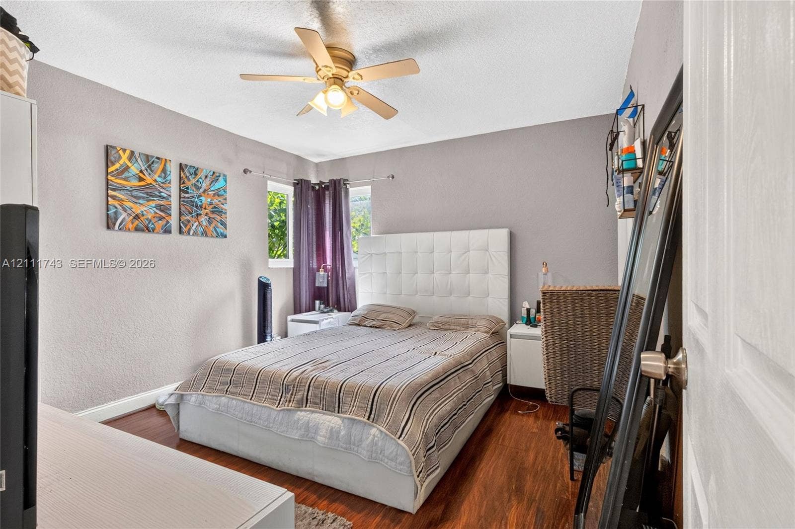 5524 N Andrews Avenue, Oakland Park, FL 33309 Bedroom featuring wood-finish flooring, a ceiling fan with integrated lighting, dual windows, and textured wall finish