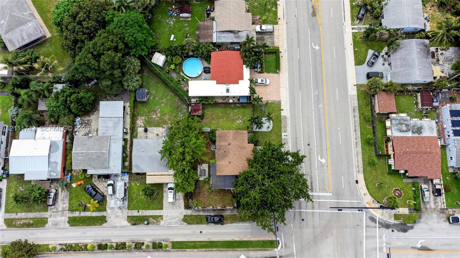 5524 N Andrews Avenue, Oakland Park, FL 33309 Aerial view of the residential property featuring mature trees, landscaped lawns, and paved driveway access