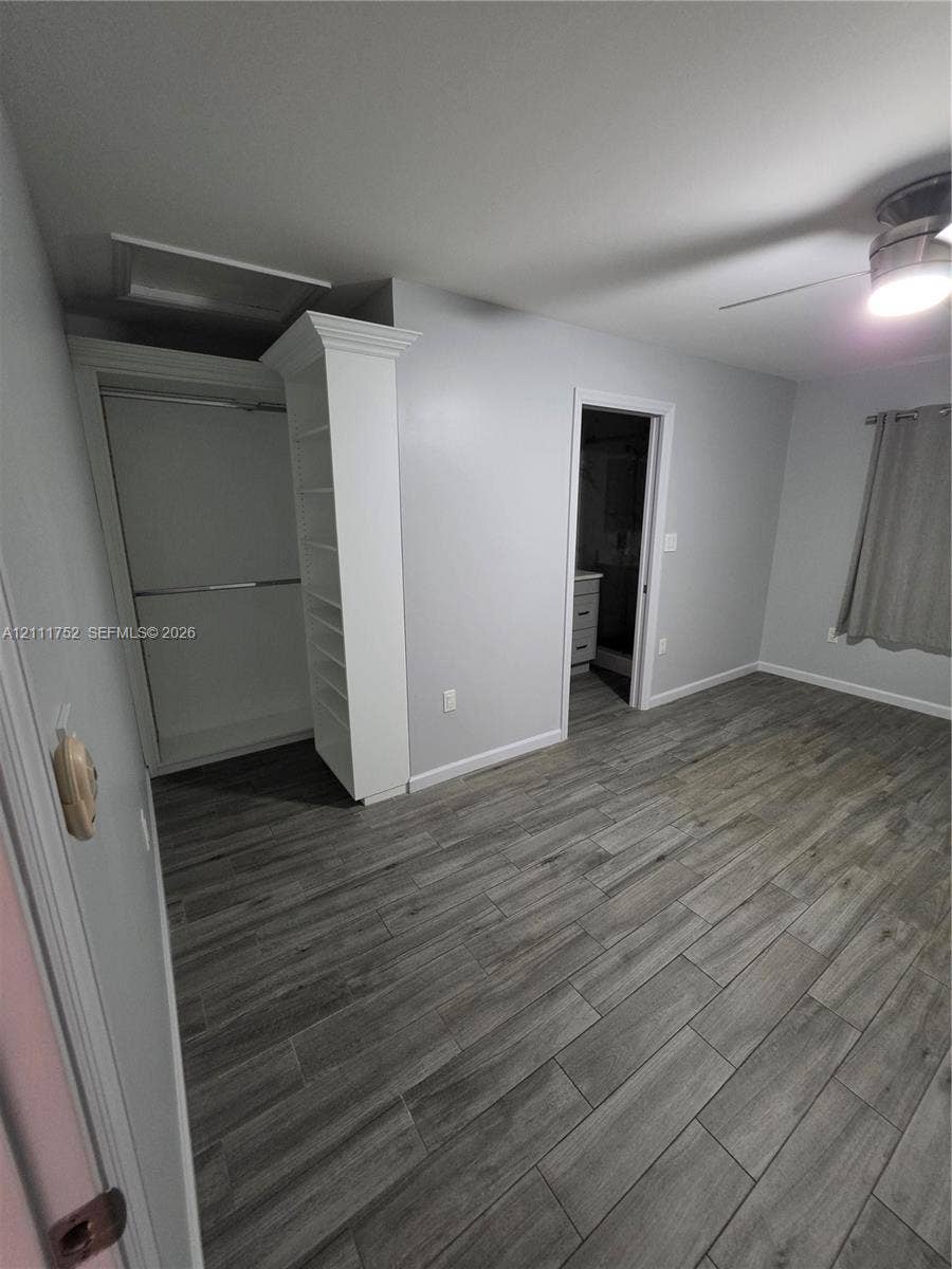 2901 NE 11th Terrace, Pompano Beach, Pompano Beach, FL 33064 Wood-finish plank flooring, built-in floor-to-ceiling shelving, recessed ceiling fan with integrated lighting, and a closet with a decorative crown molding finish