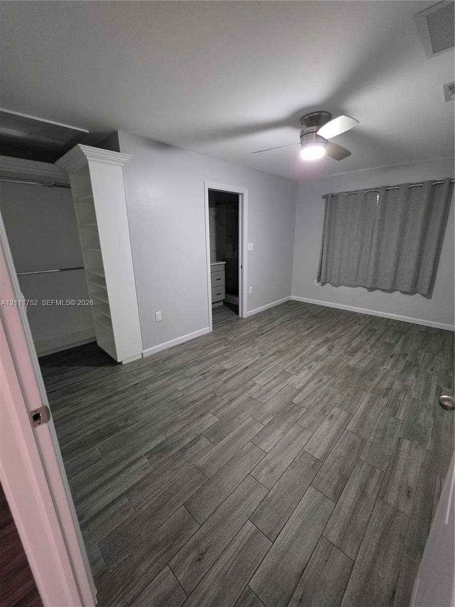 2901 NE 11th Terrace, Pompano Beach, Pompano Beach, FL 33064 Wood-finish tile flooring, ceiling fan with integrated lighting, built-in shelving, and neutral wall tones