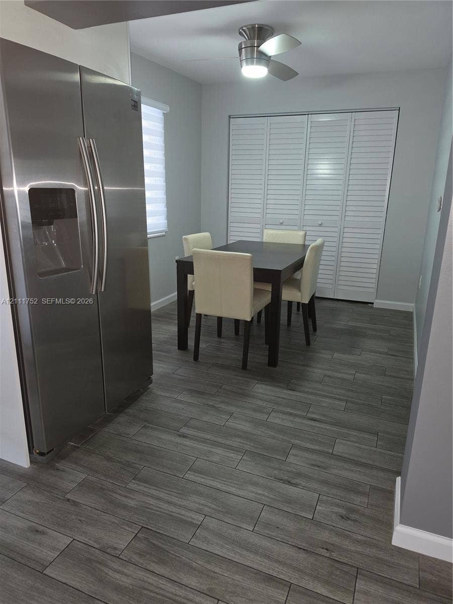 2901 NE 11th Terrace, Pompano Beach, Pompano Beach, FL 33064 Wood-finish flooring, stainless steel side-by-side refrigerator, ceiling-mounted light fixture, and floor-to-ceiling louvered closet doors