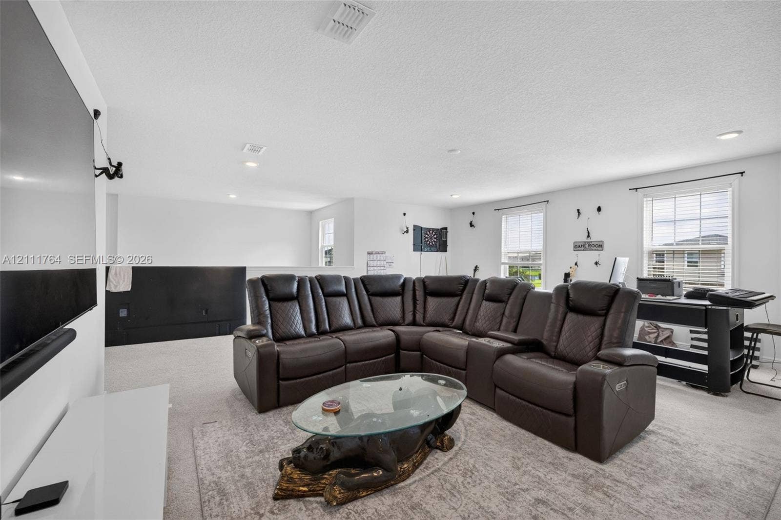 Open-concept space featuring recessed lighting, wall-to-wall carpeting, and multiple windows providing natural light