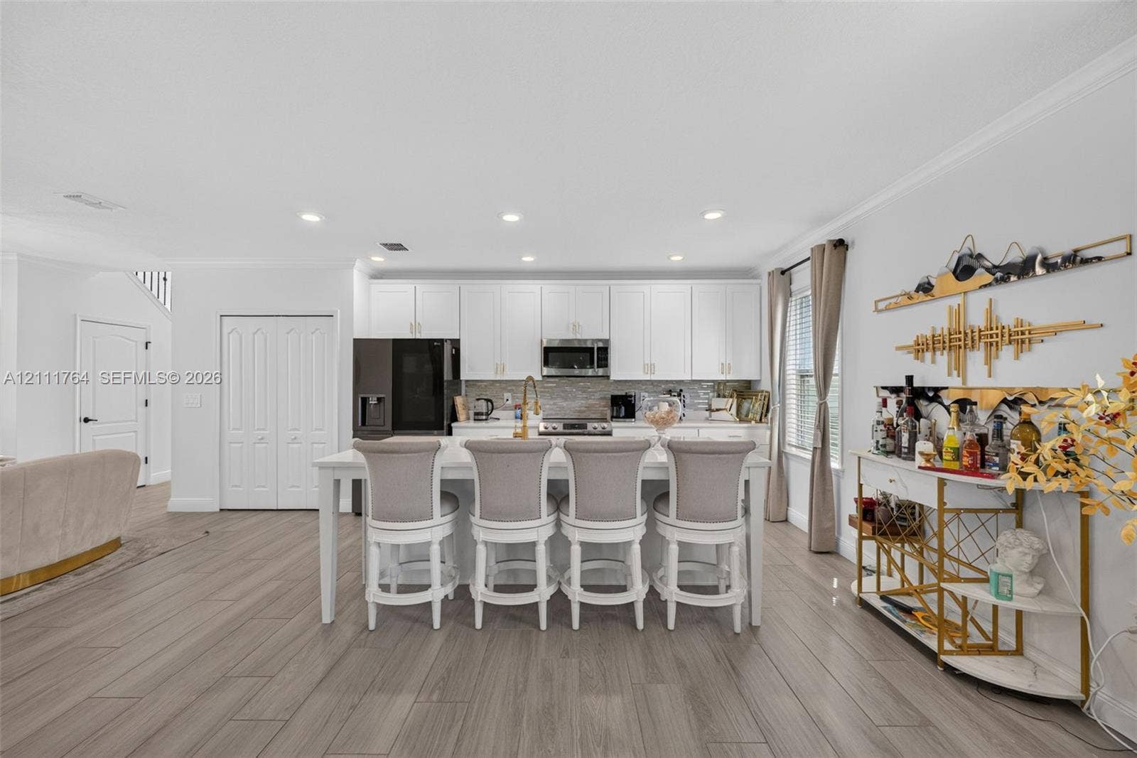 Kitchen featuring white cabinetry, wood-finish flooring, recessed lighting, and a central island with a countertop