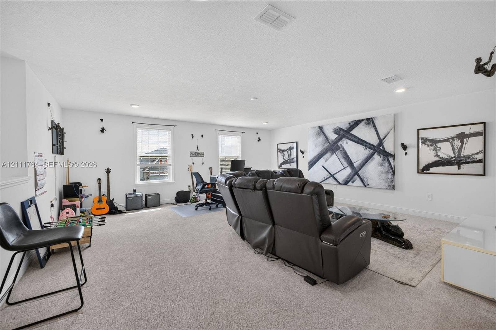 Expansive bonus room featuring neutral carpeting, recessed lighting, and multiple windows